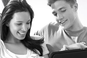 Casal num sofá a ver um tablet