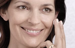 Mulher a colocar creme no rosto.