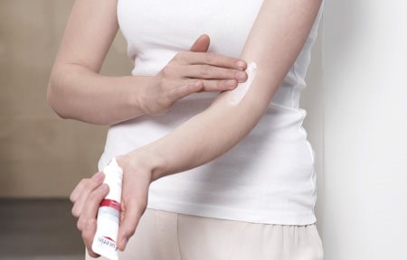 Mulher a aplicar o Creme Eucerin AtopiControl Acute Care no braço