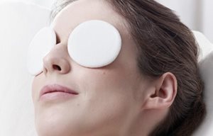 Mulher que relaxa com almofadas nos olhos.